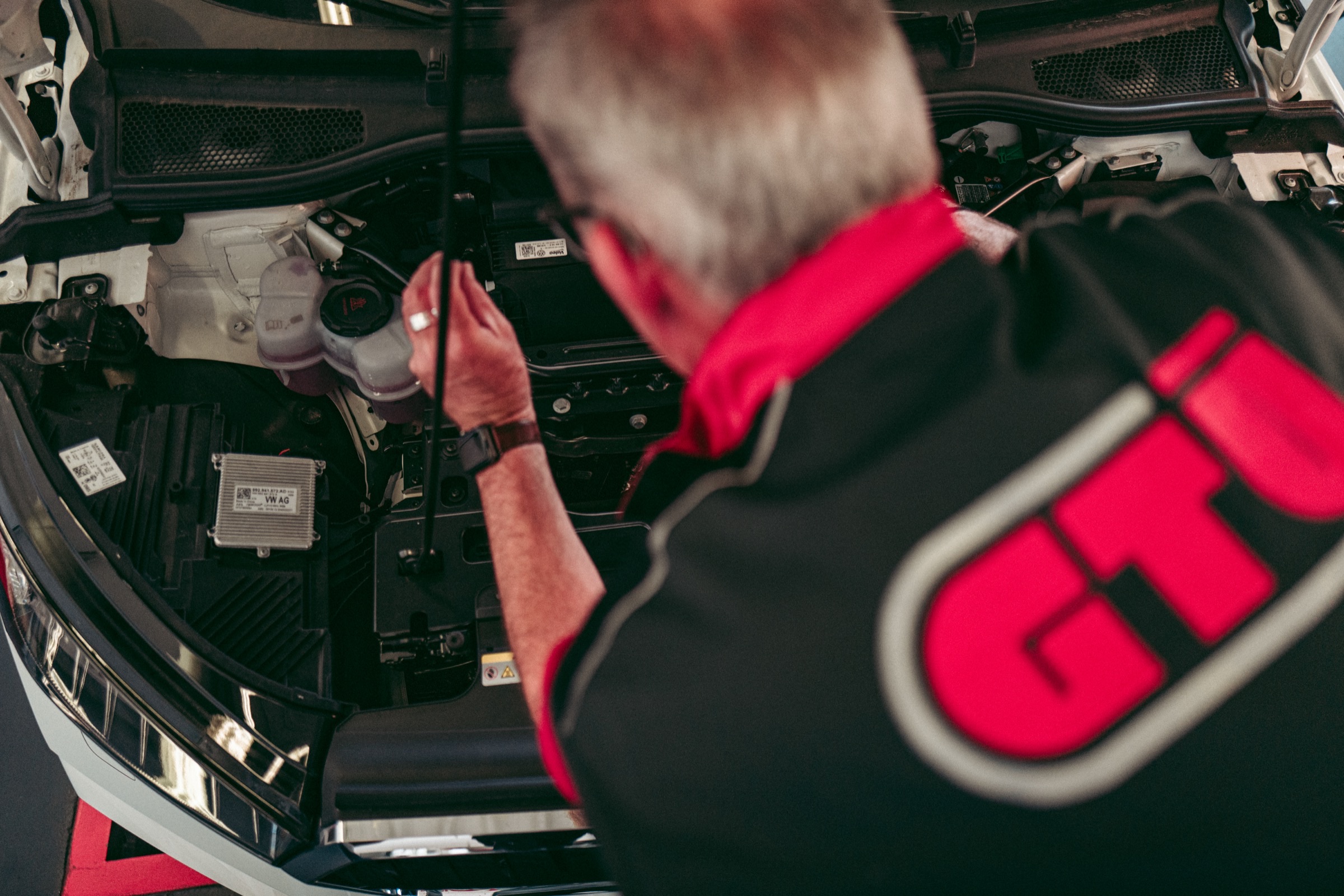 GTÜ-Prüfingenieur bei der Untersuchung am Motorraum