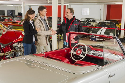 Prüfingenieur mit Kunden am Oldtimer